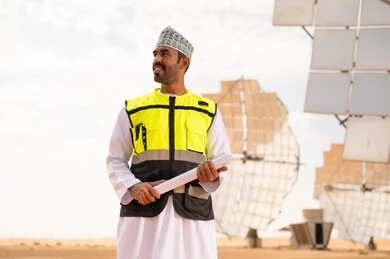 مهندس عماني في محطة طاقة شمسية مع مخططات