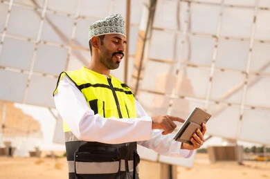 Omani Engineer Using Tablet at Solar Energy Farm