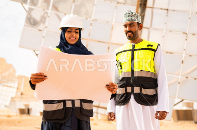 مهندسون عمانيون في محطة طاقة شمسية مع مخططات
