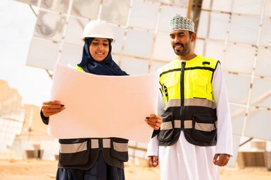 مهندسون عمانيون في محطة طاقة شمسية مع مخططات