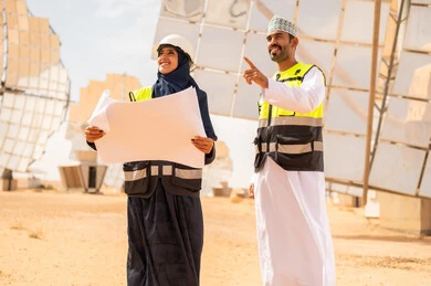 Omani Engineers at Solar Power Plant with Blueprints