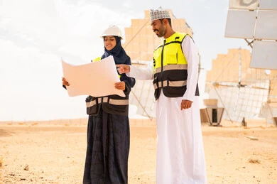 مهندسون عمانيون يراجعون مخططات في محطة طاقة شمسية