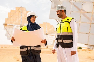 مهندسون عمانيون مع مخطط في محطة طاقة شمسية