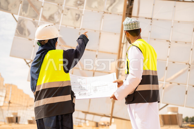 مهندسون عمانيون في محطة طاقة شمسية مع مخطط
