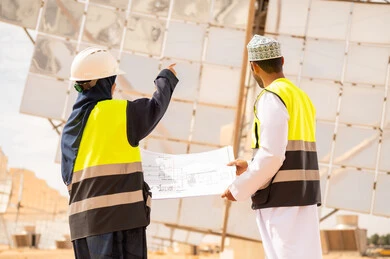 مهندسون عمانيون في محطة طاقة شمسية مع مخطط