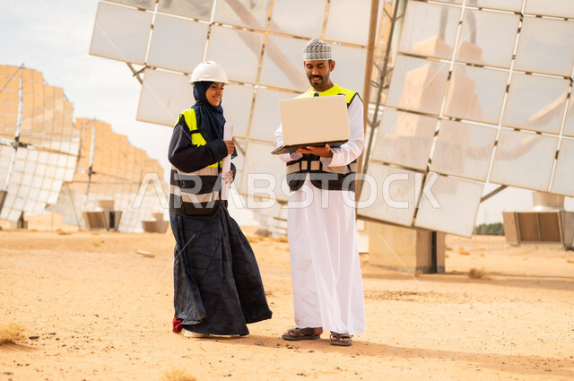مهندسون عمانيون في محطة طاقة شمسية مع كمبيوتر