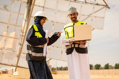 Omani Engineers Using Laptop at Solar Power Plant