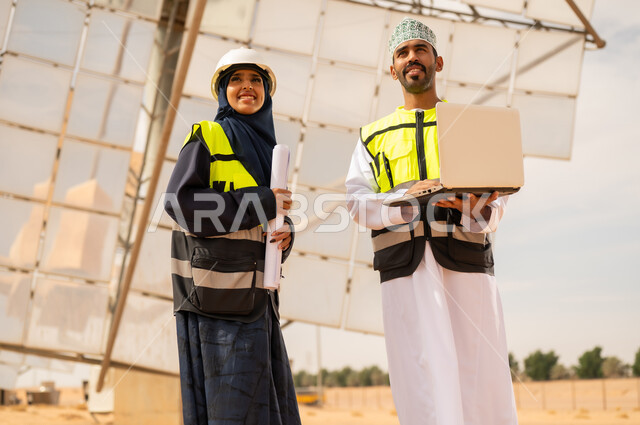 مهندسون عمانيون في محطة طاقة شمسية مع حاسوب