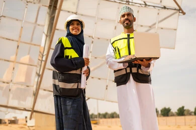 مهندسون عمانيون في محطة طاقة شمسية مع حاسوب