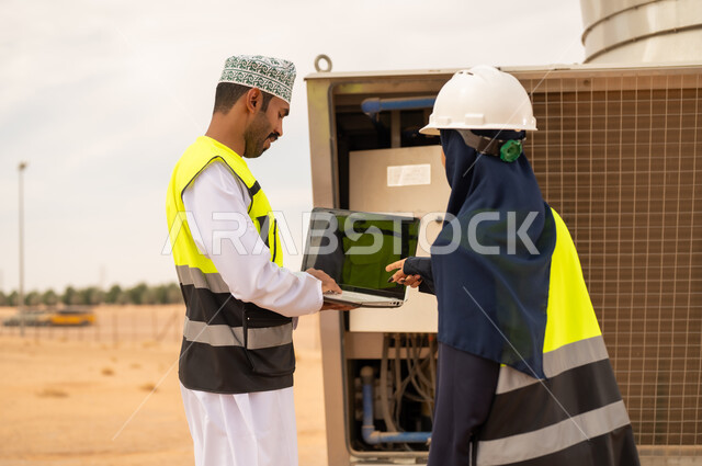 Omani Engineers Using Laptop at Industrial Site