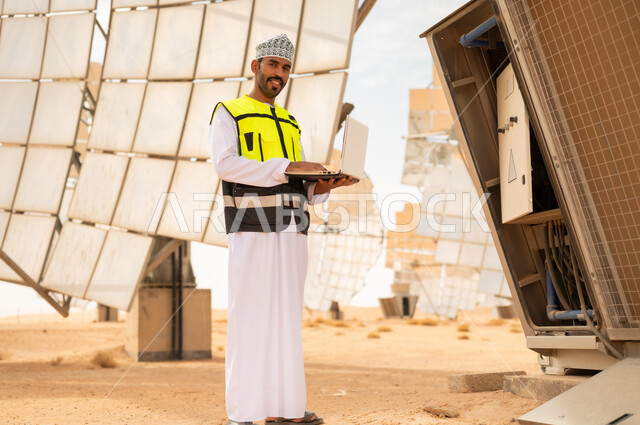 مهندس طاقة شمسية عماني يستخدم الكمبيوتر في المحطة