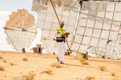 مهندس عماني في محطة طاقة شمسية مع جهاز لوحي