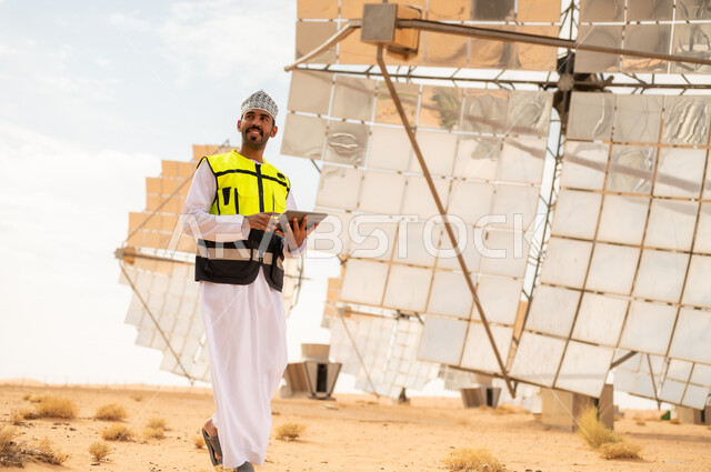 مهندس عماني مع جهاز لوحي في محطة طاقة شمسية