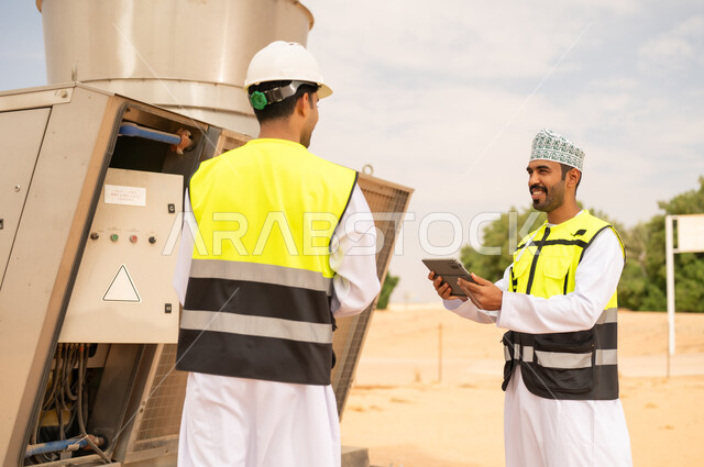 مهندسون عمانيون يفحصون معدات صناعية في الصحراء