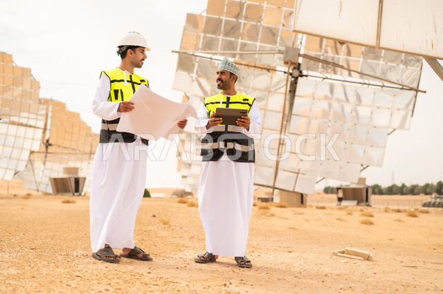 Omani Engineers at Solar Energy Farm with Blueprints
