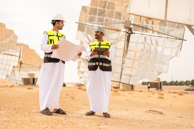 مهندسون عمانيون في محطة طاقة شمسية مع مخططات
