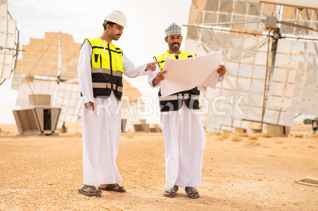 مهندسون عمانيون في محطة طاقة شمسية مع مخططات