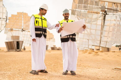 Omani Engineers at Solar Power Plant with Blueprints