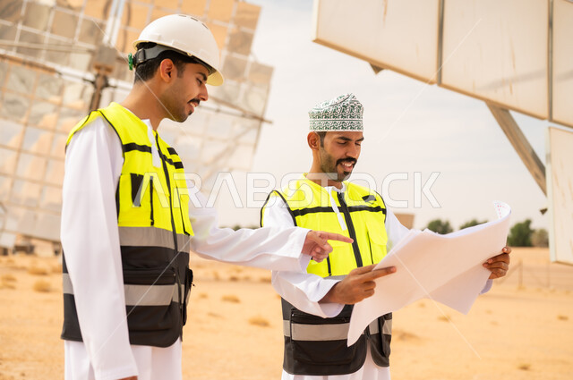مهندسون عمانيون في محطة طاقة شمسية مع مخططات هندسية