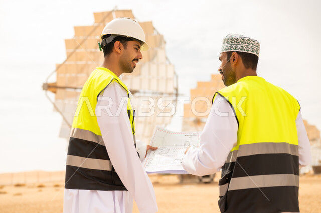 مهندسون عمانيون في محطة طاقة شمسية مع مخططات