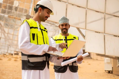 Omani Engineers at Solar Power Station with Laptop
