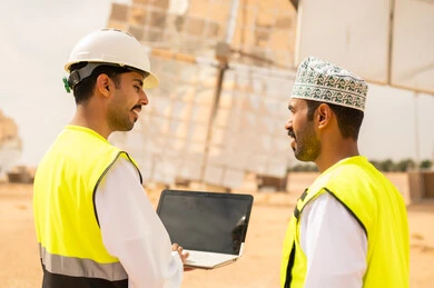 Omani Engineers at Solar Power Plant with Laptop
