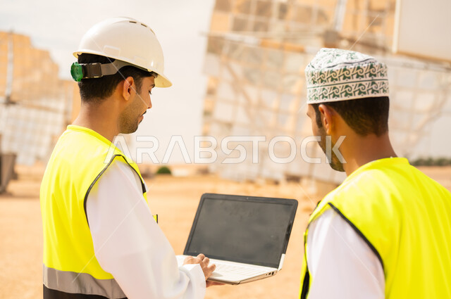 Omani Engineers Using Laptop at Solar Power Plant