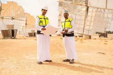 Omani Engineers at Solar Power Plant with Blueprints