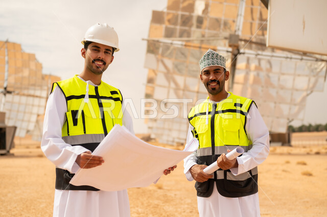 مهندسون عمانيون في محطة طاقة شمسية مع مخططات