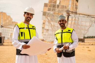 مهندسون عمانيون في محطة طاقة شمسية مع مخططات