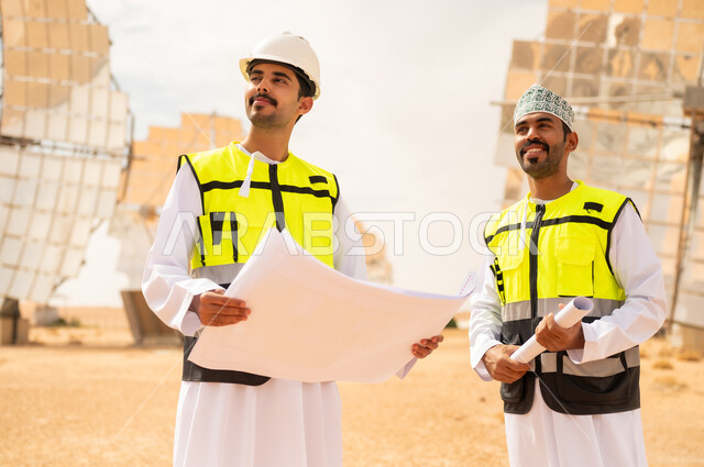 مهندسون عُمانيون في محطة طاقة شمسية مع مخططات