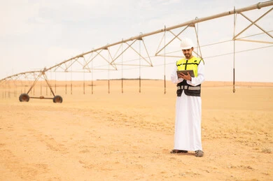 Saudi Engineer Using Tablet at Desert Irrigation Site