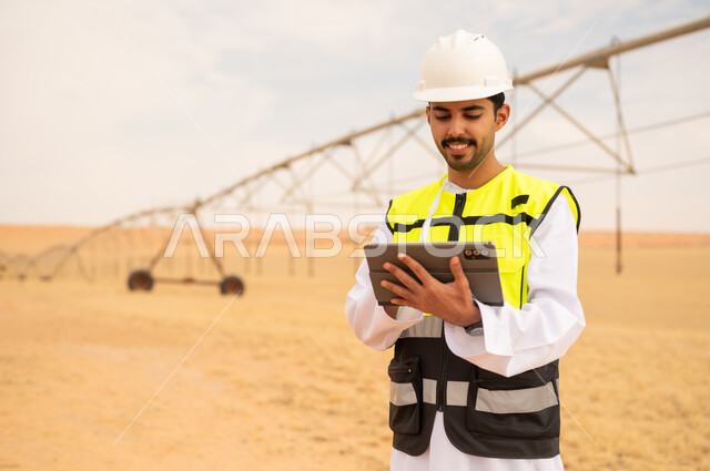 مهندس عربي بجهاز لوحي في موقع ري صحراوي