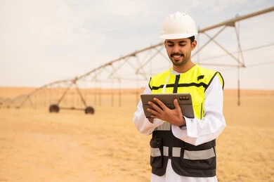 مهندس عربي بجهاز لوحي في موقع ري صحراوي
