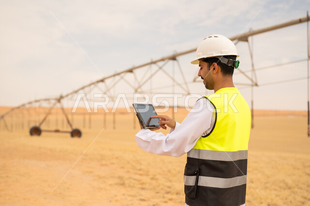 مهندس سعودي يستخدم جهاز لوحي في مزرعة صحراوية