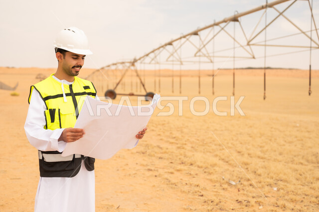 مهندس عربي مع مخطط هندسي في موقع ري صحراوي