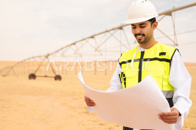 Saudi Engineer Reviewing Blueprints at Desert Site