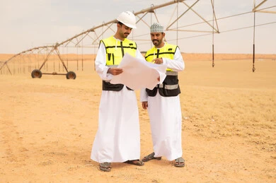 Omani Engineers Reviewing Blueprints in Desert Site