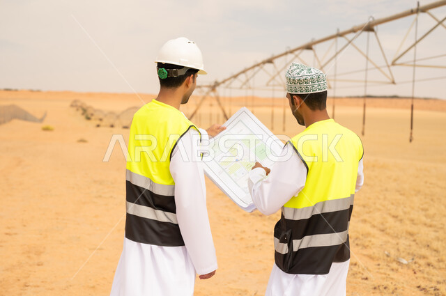 Omani Engineers Reviewing Blueprints at Desert Farm