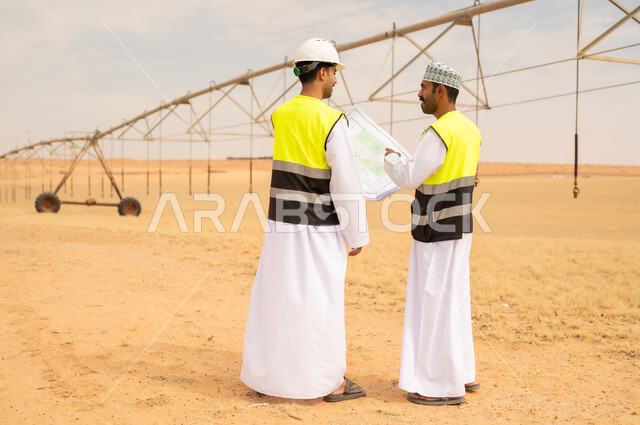 Omani Engineers Reviewing Irrigation Plans in Desert Farm