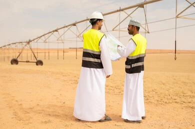 Omani Engineers Reviewing Irrigation Plans in Desert Farm