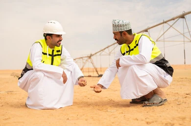 مهندسان زراعيان عُمانيان يتفحصان التربة في الصحراء مهندسان زراعيان عُمانيان يتفحصان التربة في الصحراء