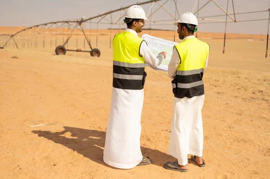 مهندسون سعوديون يناقشون المخططات في مشروع صحراوي