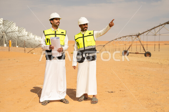 Saudi Engineers in Desert Solar Farm with Blueprints