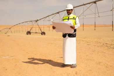 Saudi Engineer With Blueprints at Irrigation Site