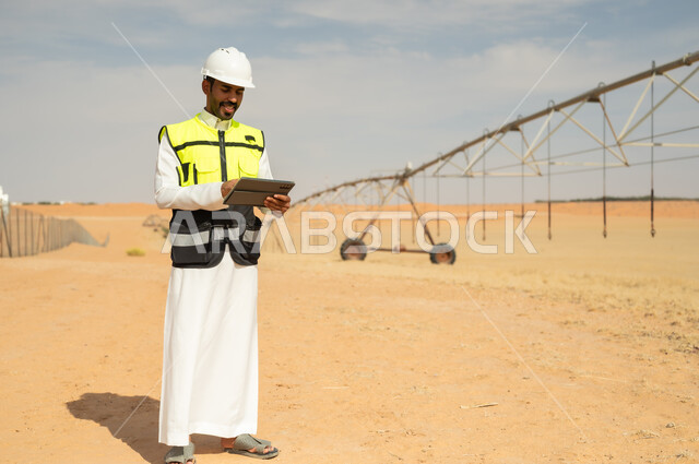مهندس سعودي في مزرعة صحراوية يستخدم جهاز لوحي