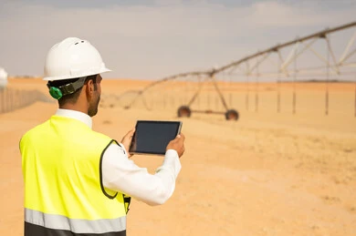 مهندس عربي بجهاز لوحي في مزرعة ري صحراوية