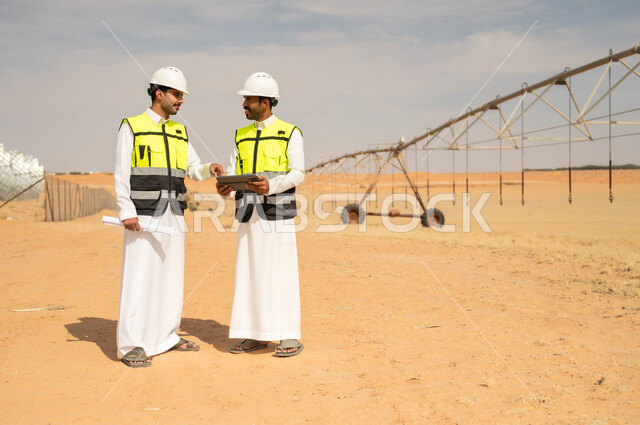 مهندسون سعوديون يستخدمون جهاز لوحي في مزرعة ري صحراوية