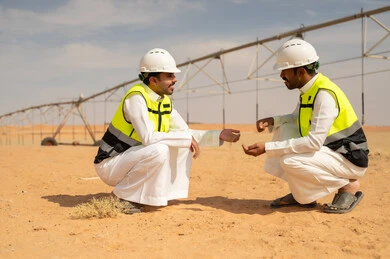 مهندسون سعوديون في مزرعة صحراوية مع نظام ري