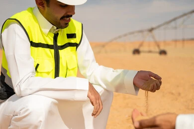 Saudi Engineer Inspecting Soil at Desert Farm
